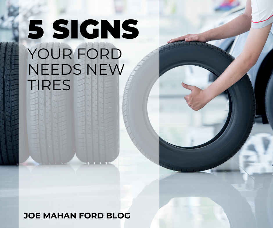 A photo containing tires on a showroom floor and a technician holding one and text that reads: 5 Signs your Ford needs new tires - Joe Mahan Ford Blog